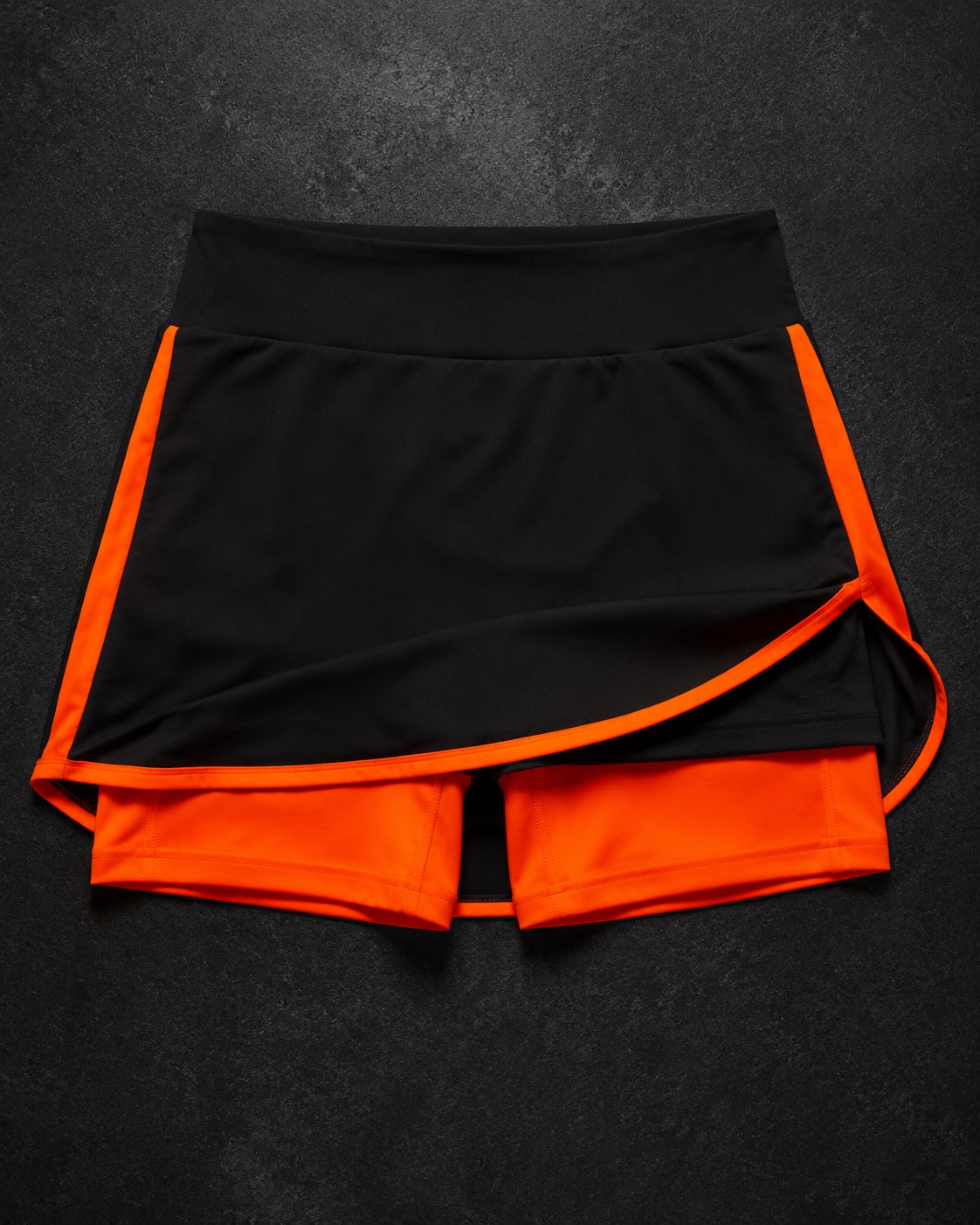 Field hockey skort with an inner short, flat lay on dark charcoal