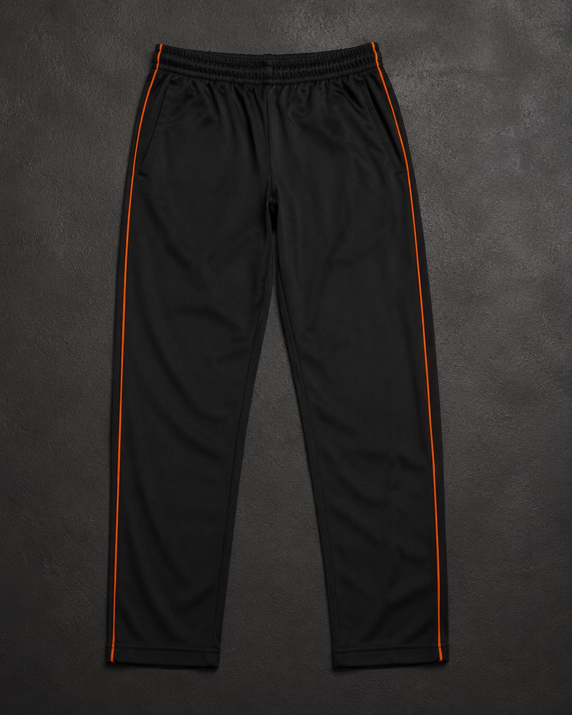 Coloured cricket trousers with contrast side piping, flat lay on dark charcoal
