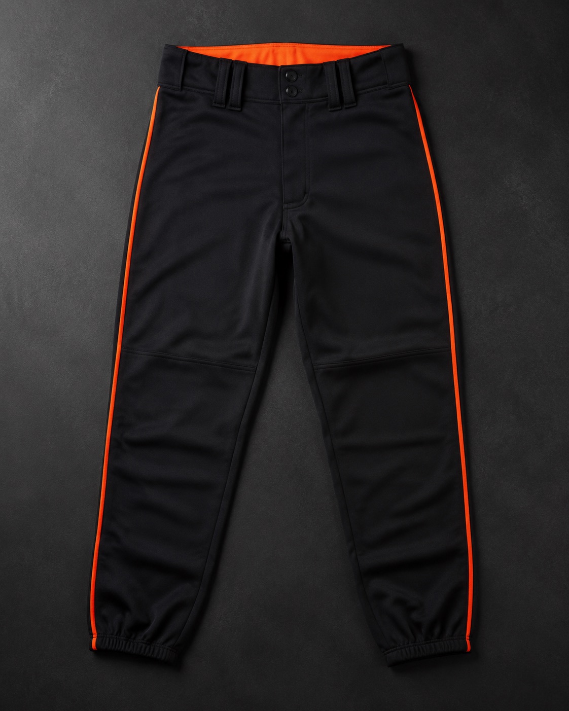 Full-length baseball pants with piping, flat lay on dark charcoal