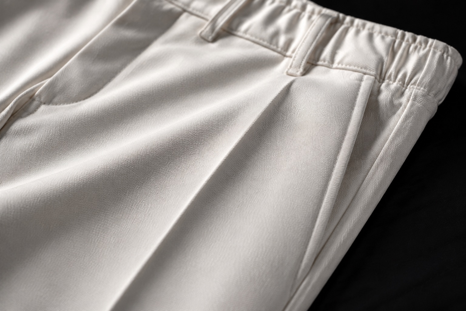 Close detail of white poly-viscose cricket trousers showing a pressed crease and twill weave