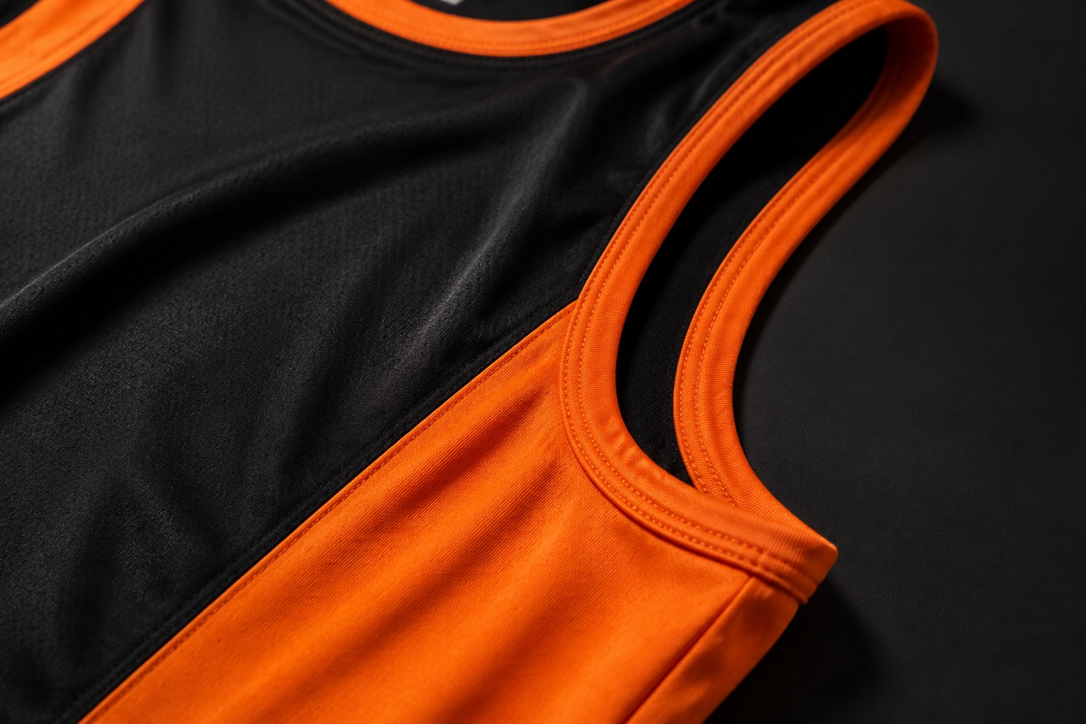 Close detail of a lightweight athletics vest showing bound armhole edges