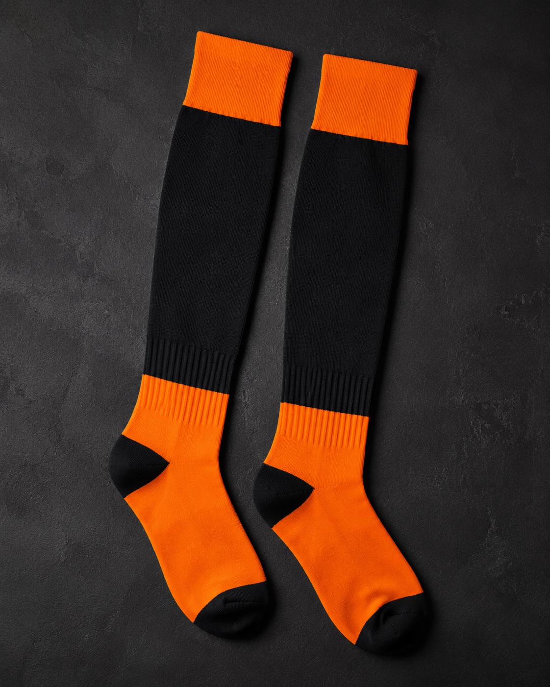 Tall field hockey socks, flat lay on dark charcoal