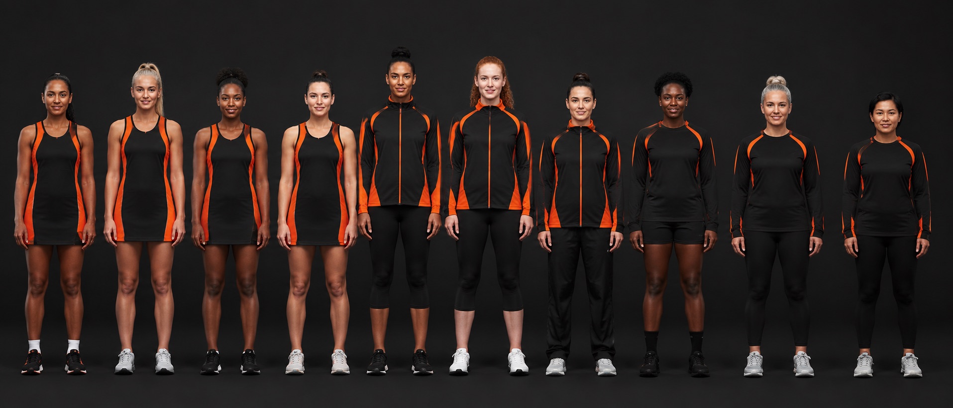 Netball players side by side wearing the full club range, from match dress to warm-up jacket