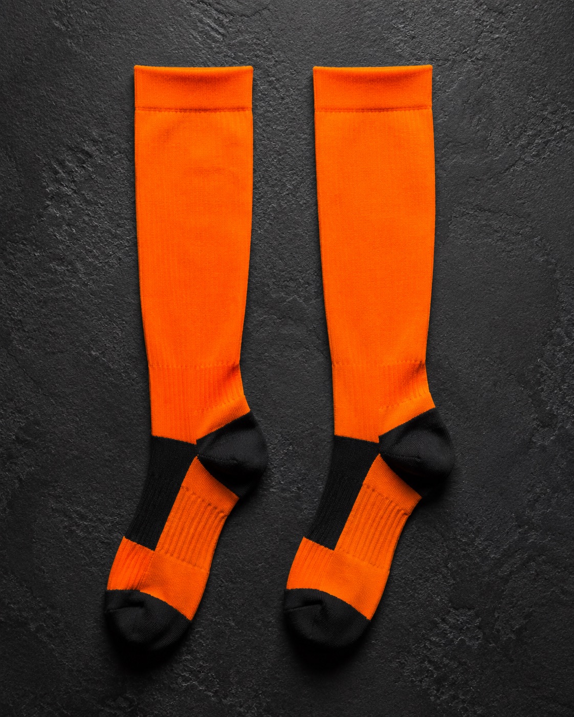 Tall American football team socks, flat lay on dark charcoal