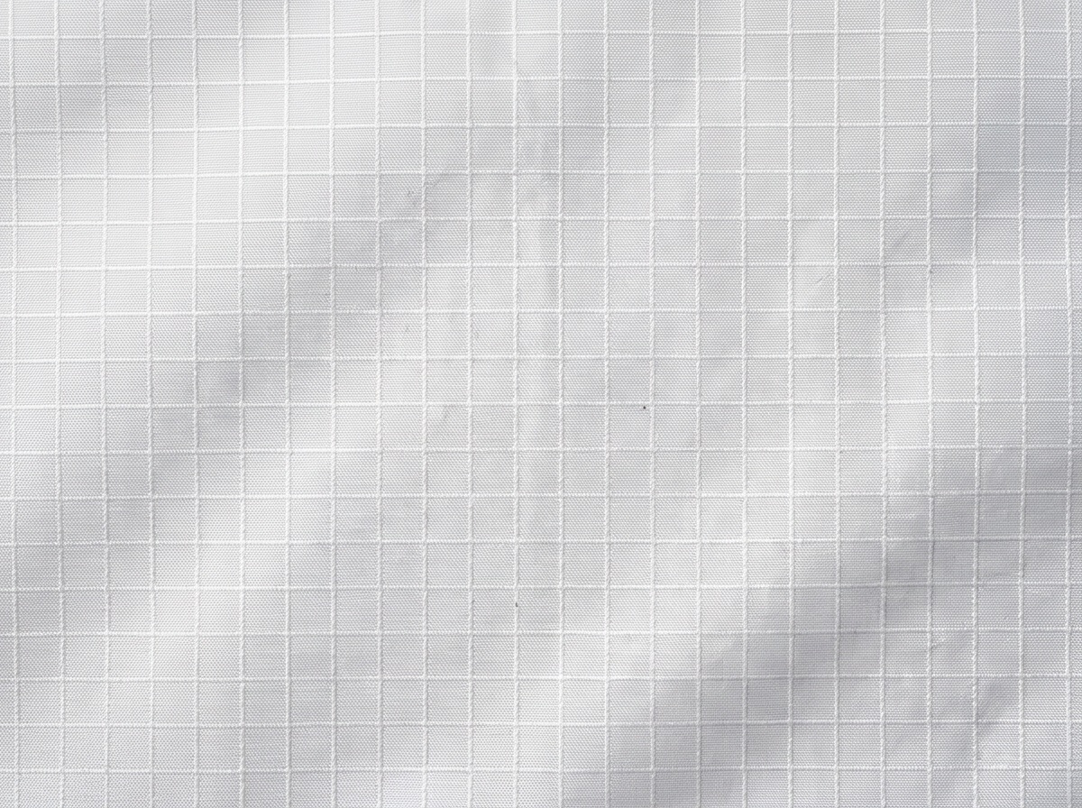Extreme macro of white ripstop shell showing the reinforcing grid weave