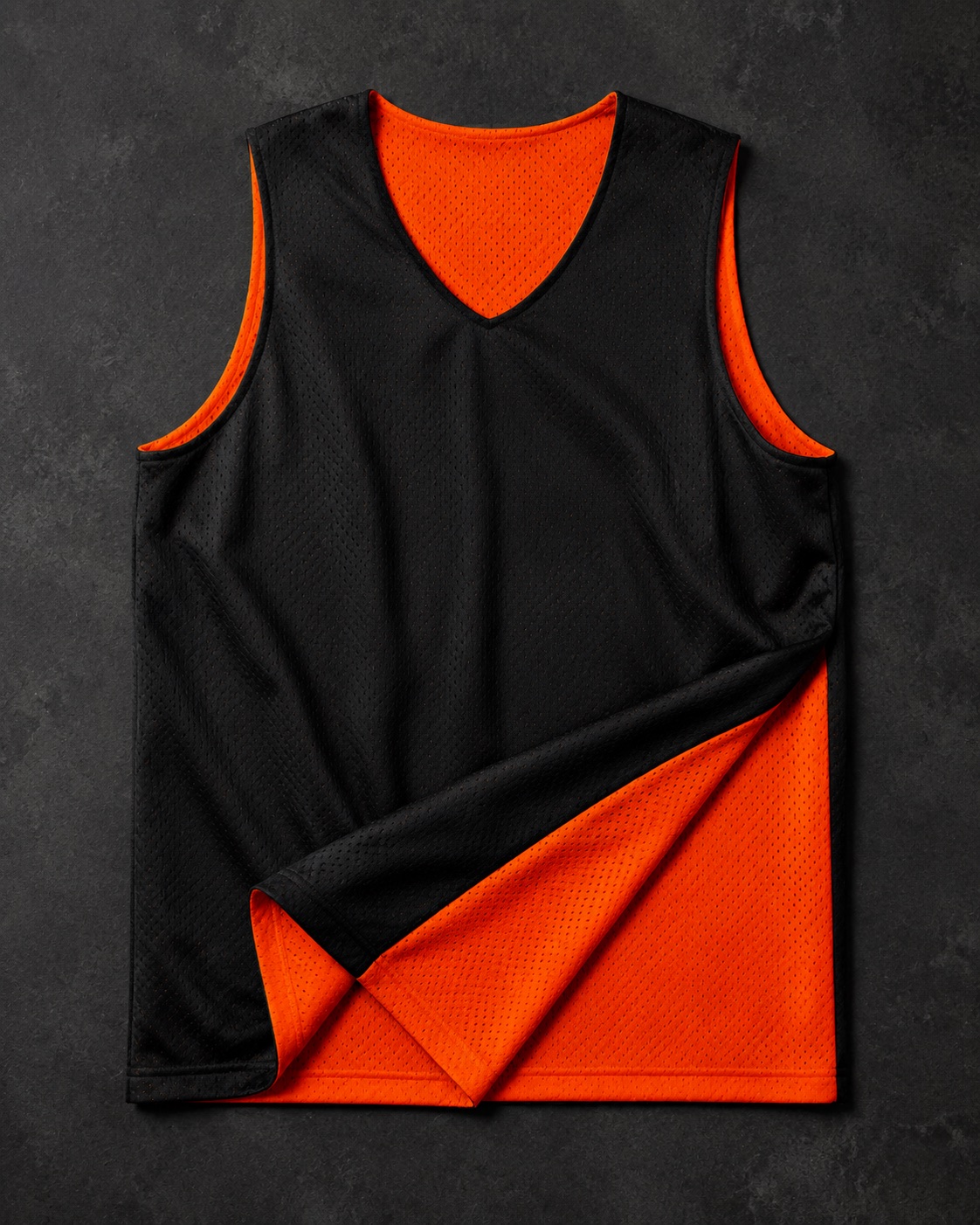 Reversible basketball practice jersey folded to show faces, flat lay