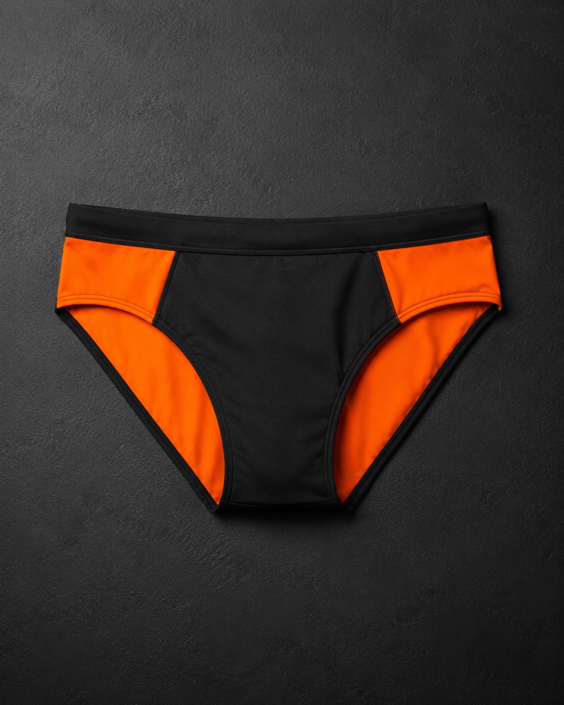 Athletics sprint briefs, flat lay on dark charcoal