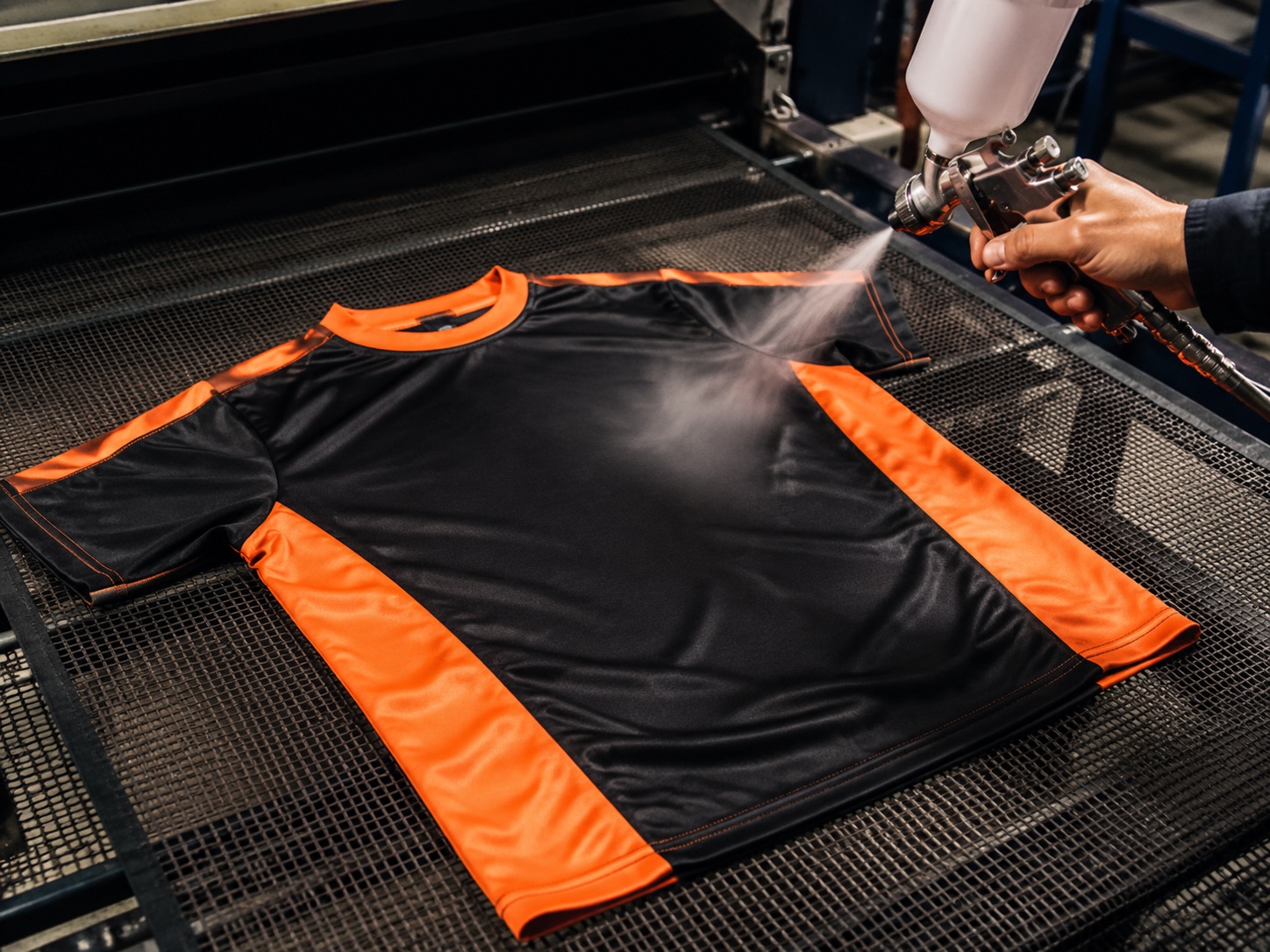 Garment being sprayed with pre-treatment solution before direct-to-garment printing