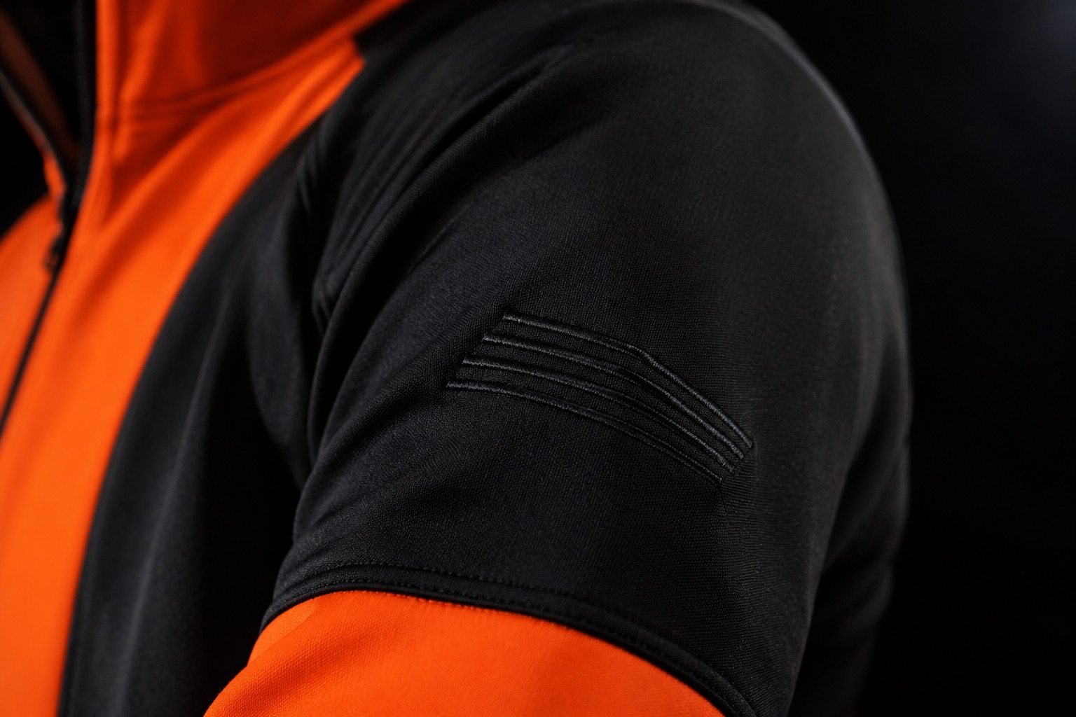 Close detail of tonal embroidery on a dark jacket sleeve