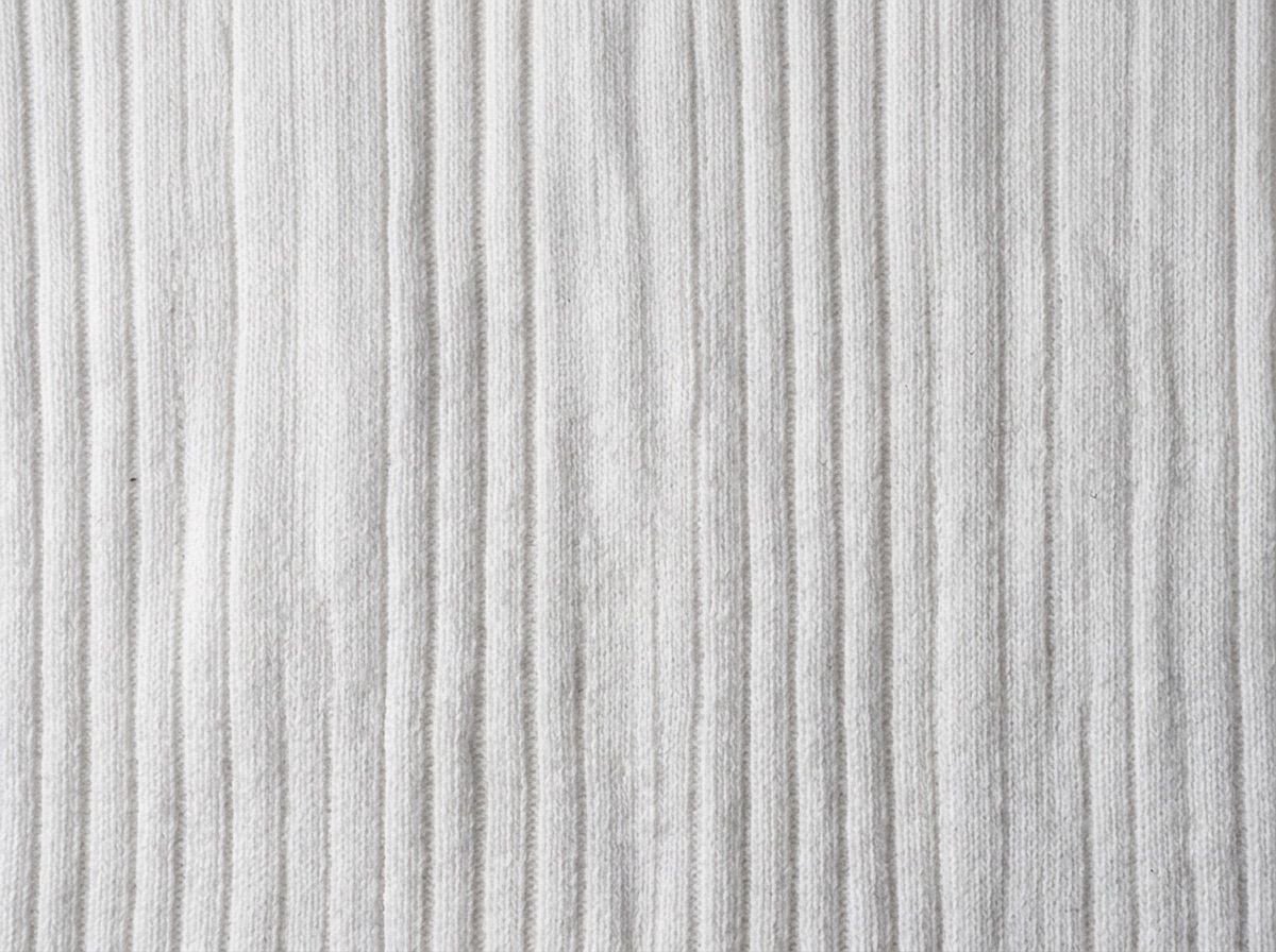 Extreme macro of white 1x1 rib knit showing alternating raised ribs