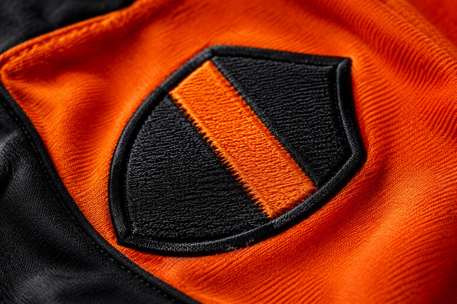 Macro of a densely embroidered club crest showing individual thread stitches and raised texture
