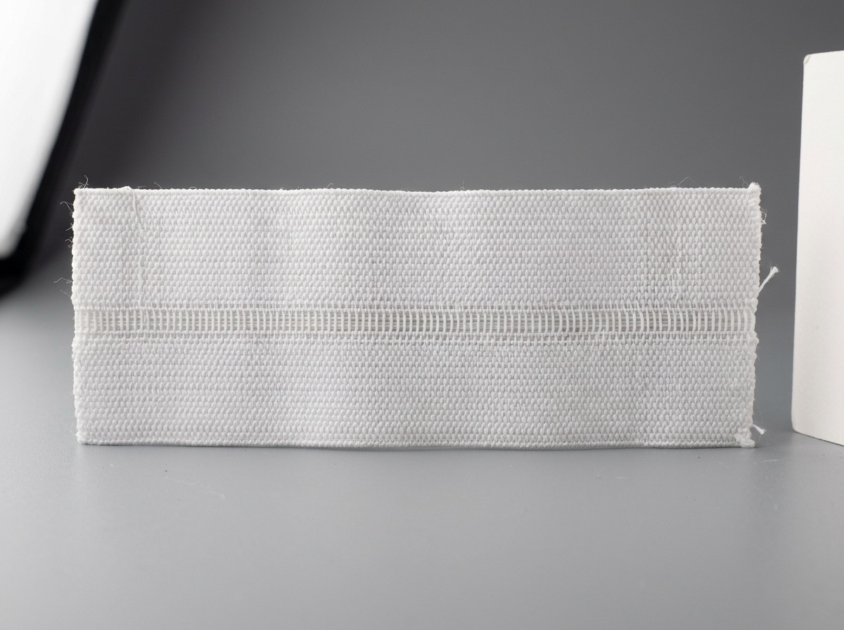 Extreme macro of white woven elastic waistband tape showing rubber threads