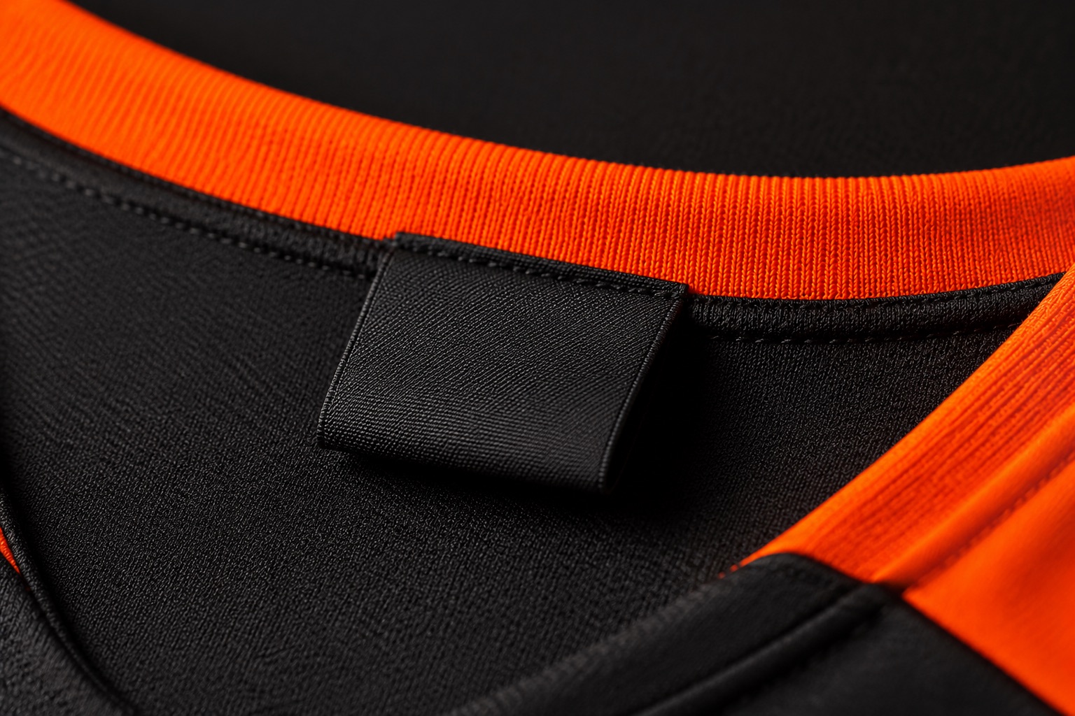 Close detail of a loop-fold woven label stitched into a garment neck seam