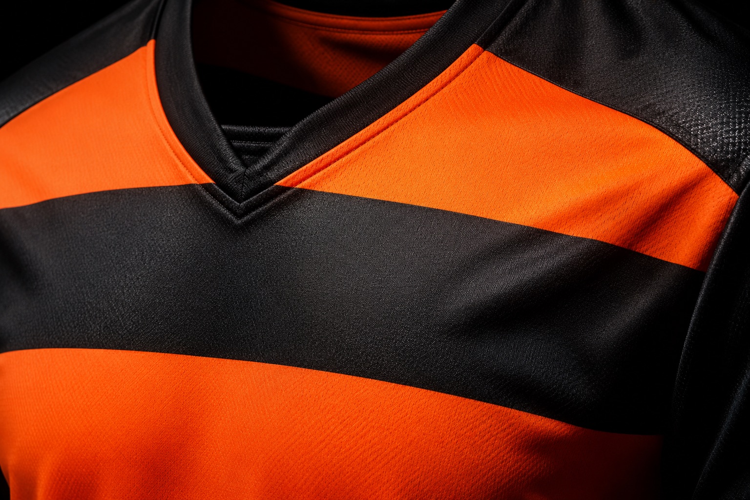 Close detail of a sublimated hooped football jersey with an embroidered club crest